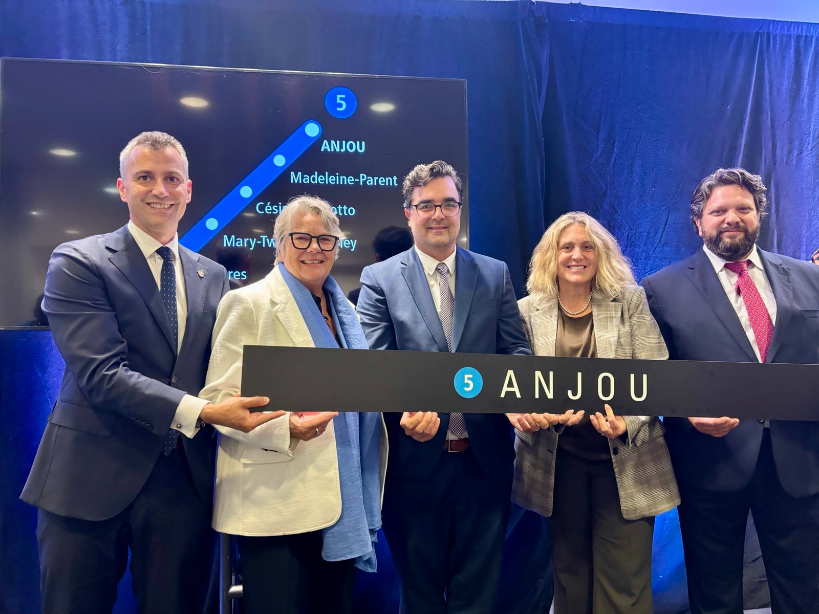 Eric St-Pierre tient l'enseigne de la future station Anjou de la ligne bleue